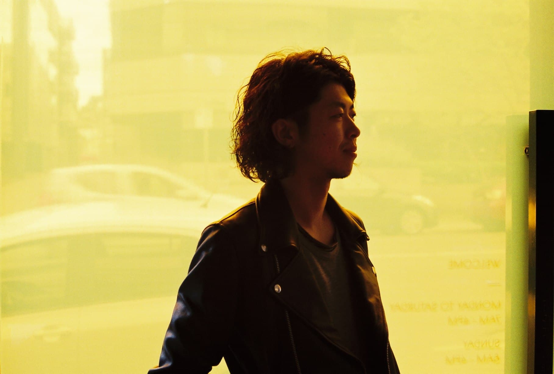 A silhouetted portrait against a bright yellow window.