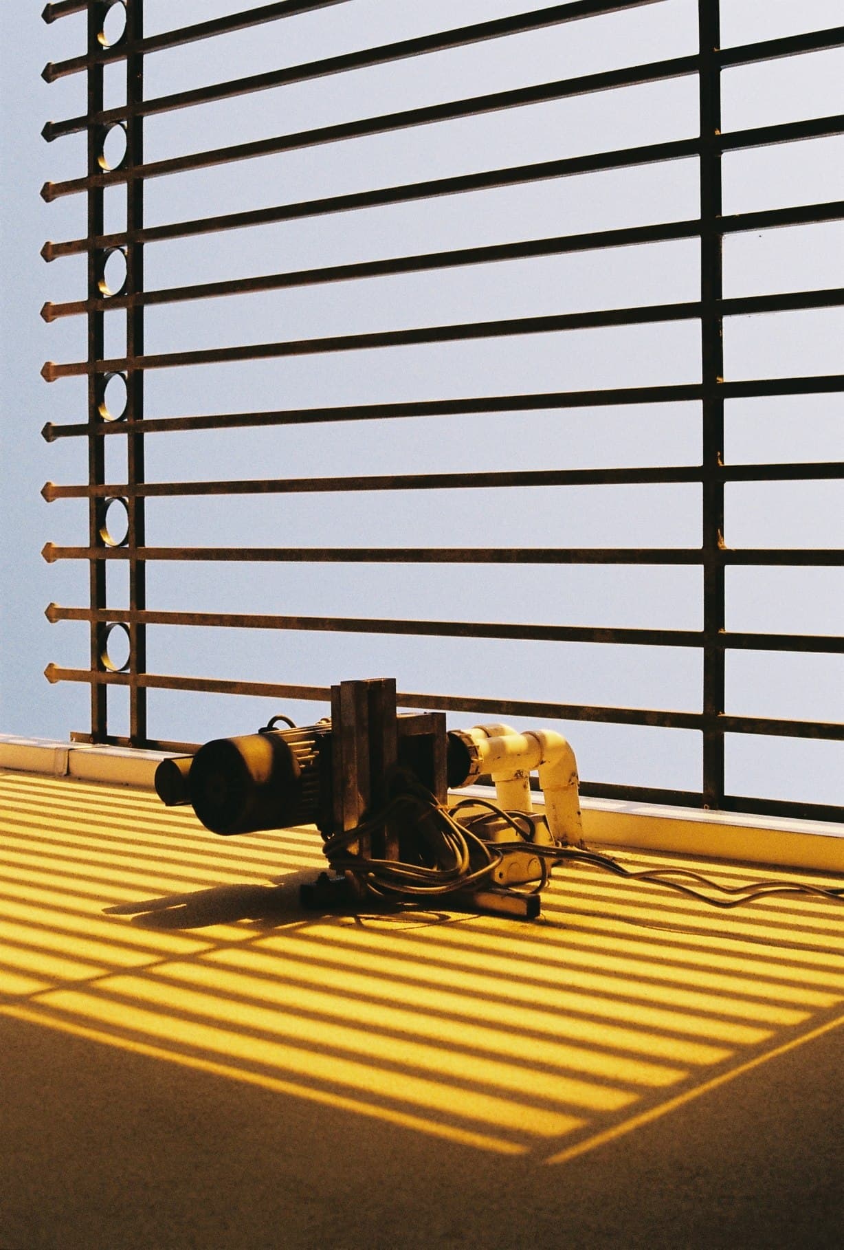 Small objects casting shadows across a yellow surface.