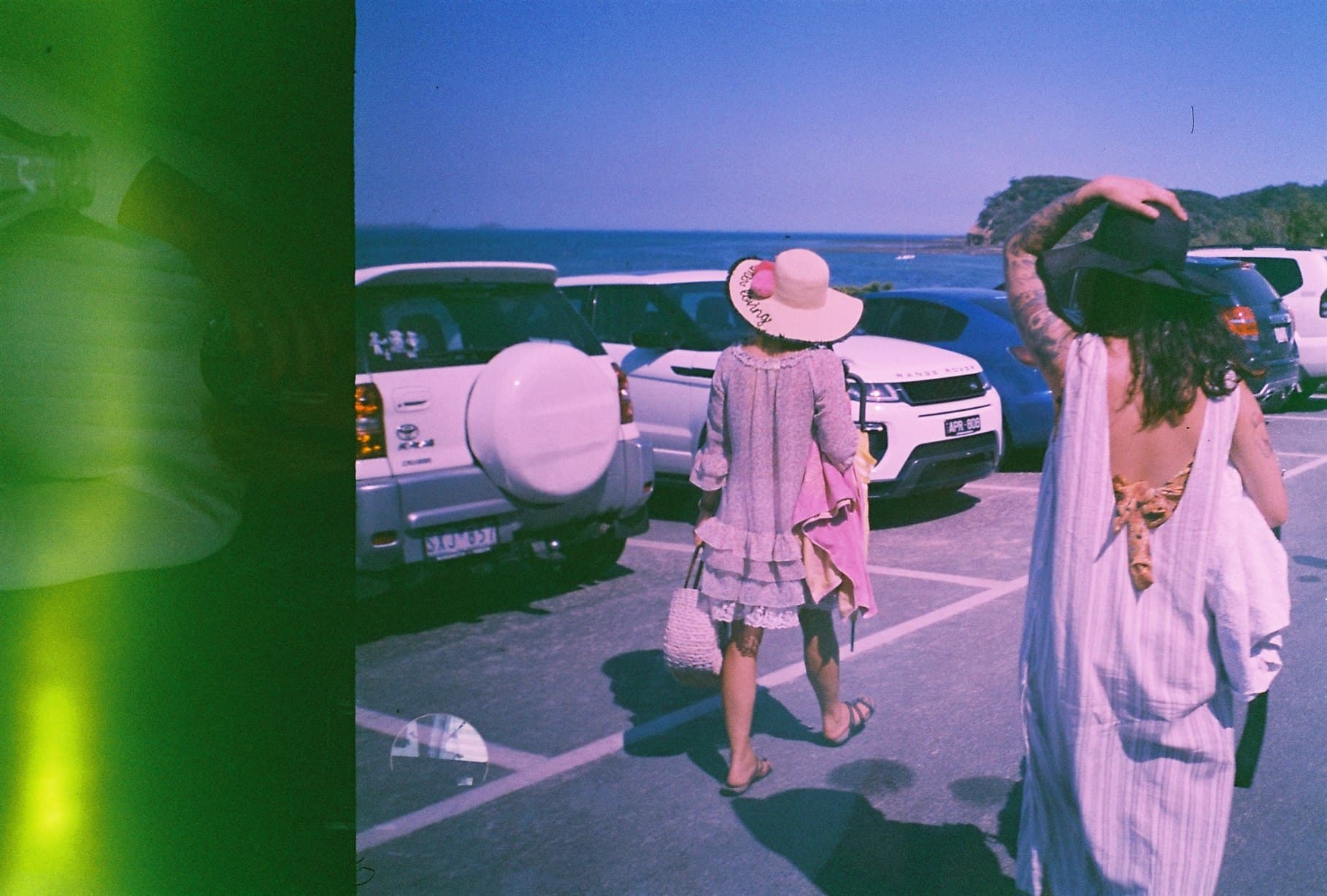 Colour-shifted street photograph of pedestrians near a car.