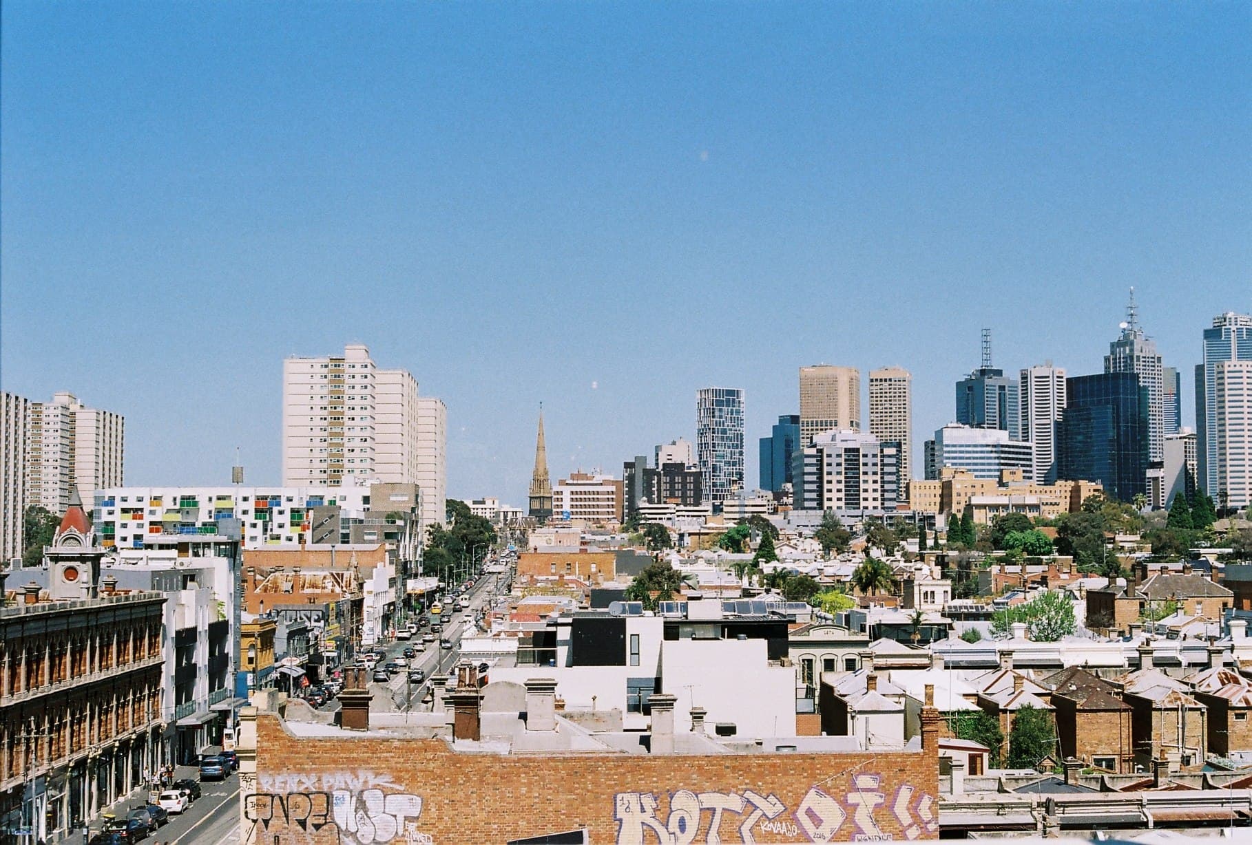 A view across city rooftops and a distant skyline.