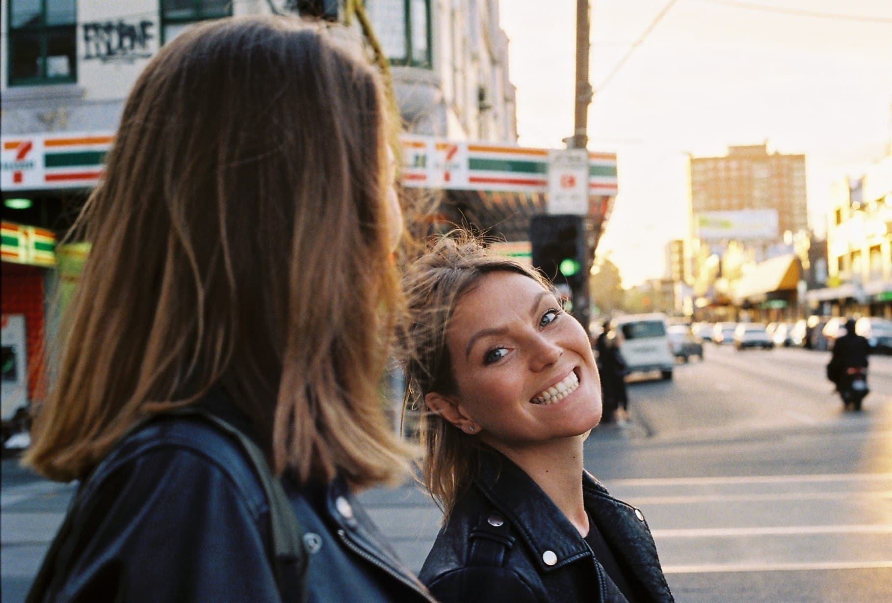 Two people on a busy city street, one looking towards the camera.