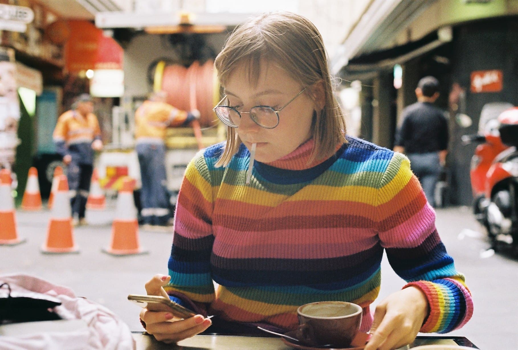 A person in a striped top looking at a phone.