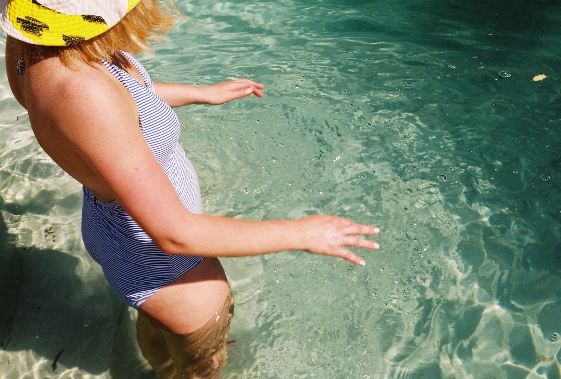 A person standing in clear turquoise water.
