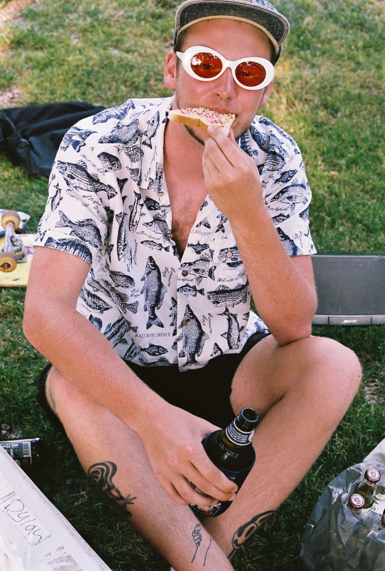 A person in sunglasses seated outdoors in sunshine.