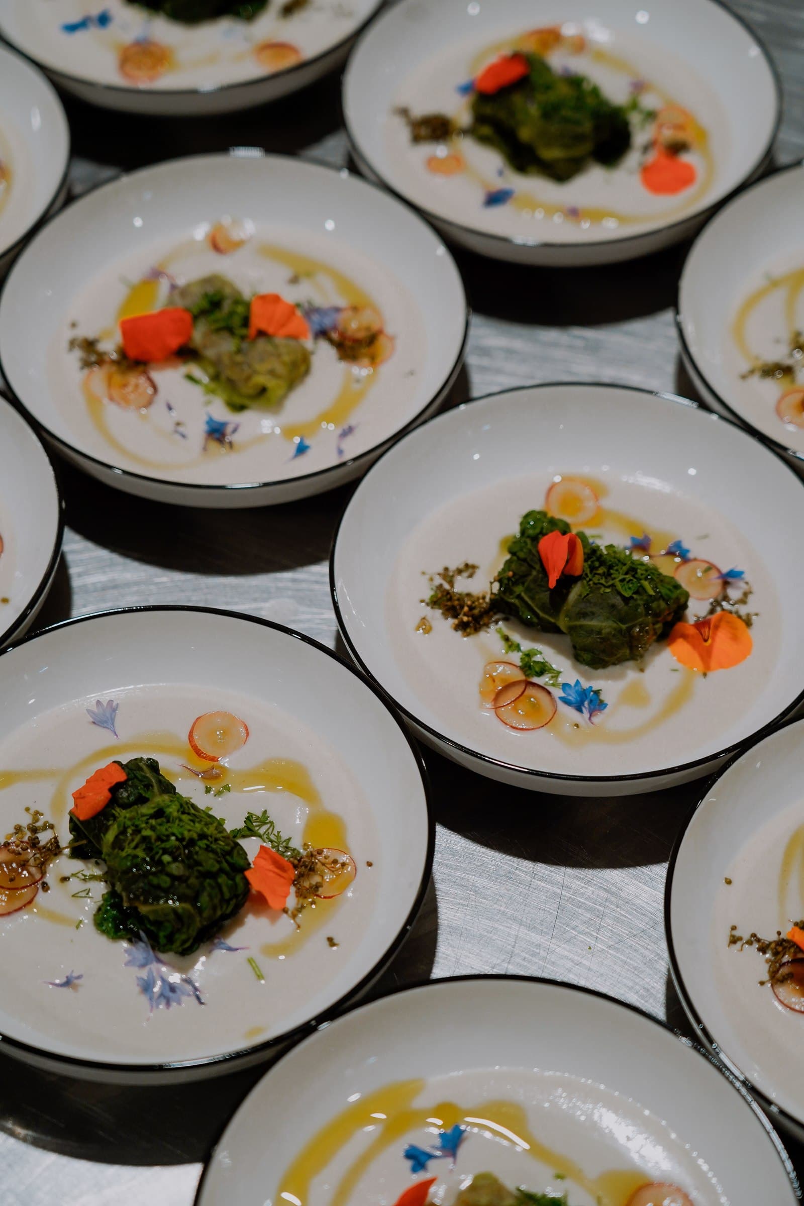 Several finished plates of vegetables arranged ready for service.