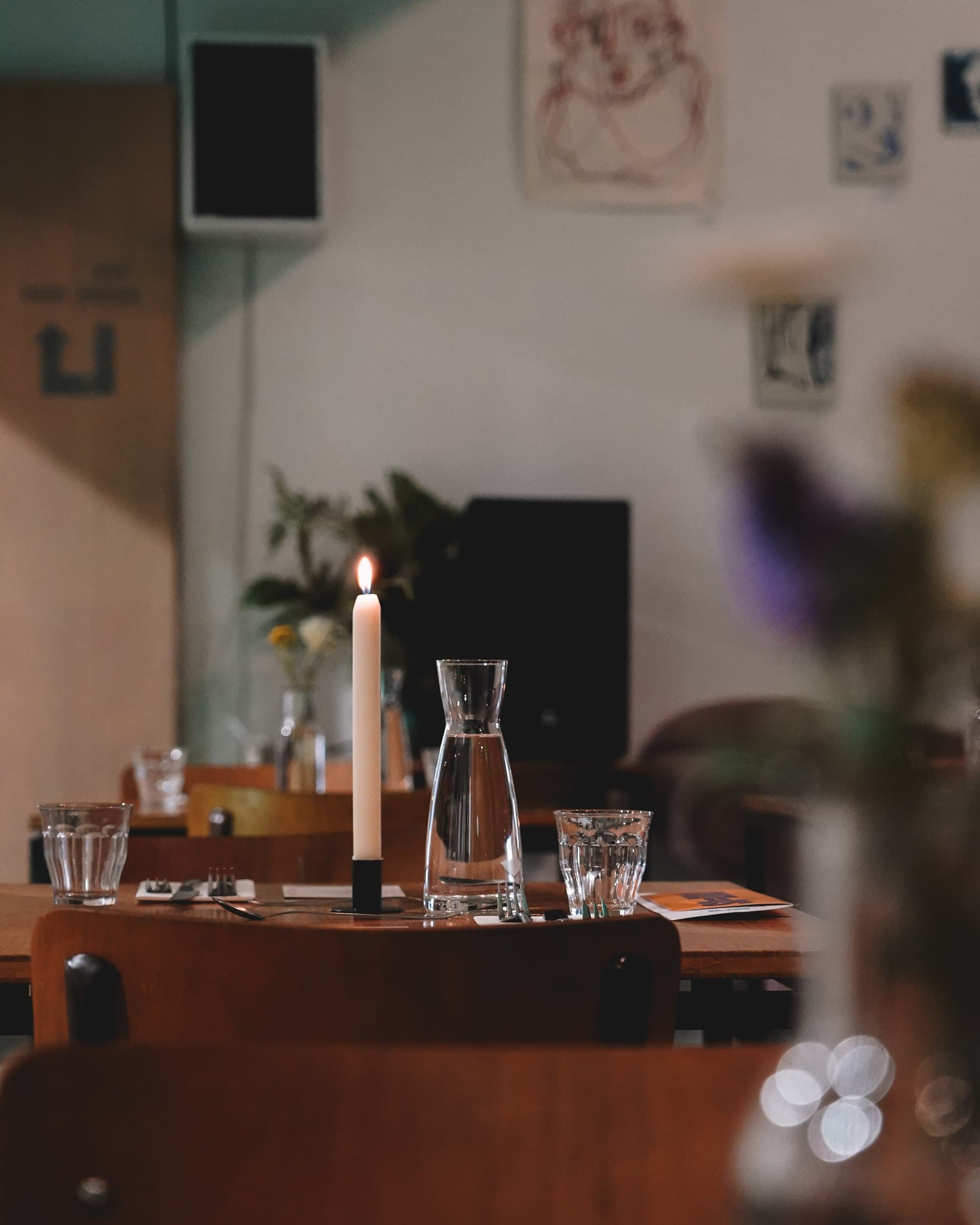 A softly lit dining table with glasses and candles.
