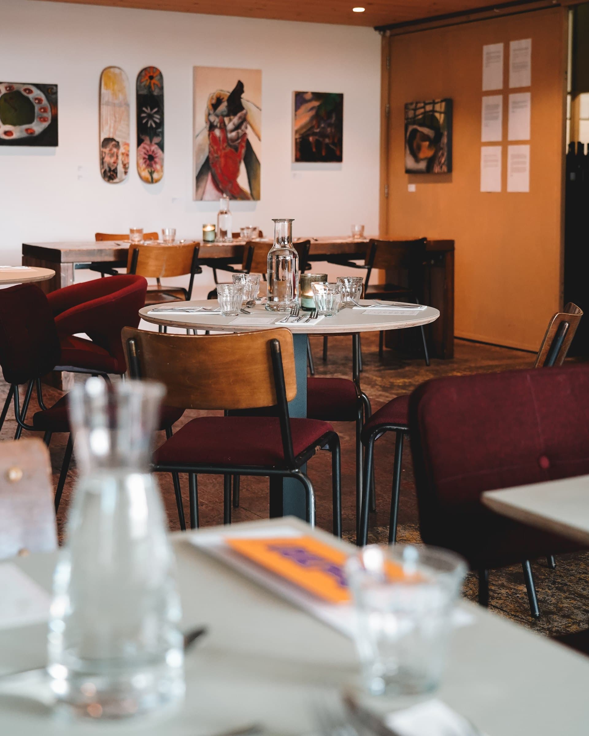 Sunlight falling across tables and glasses in the dining room.