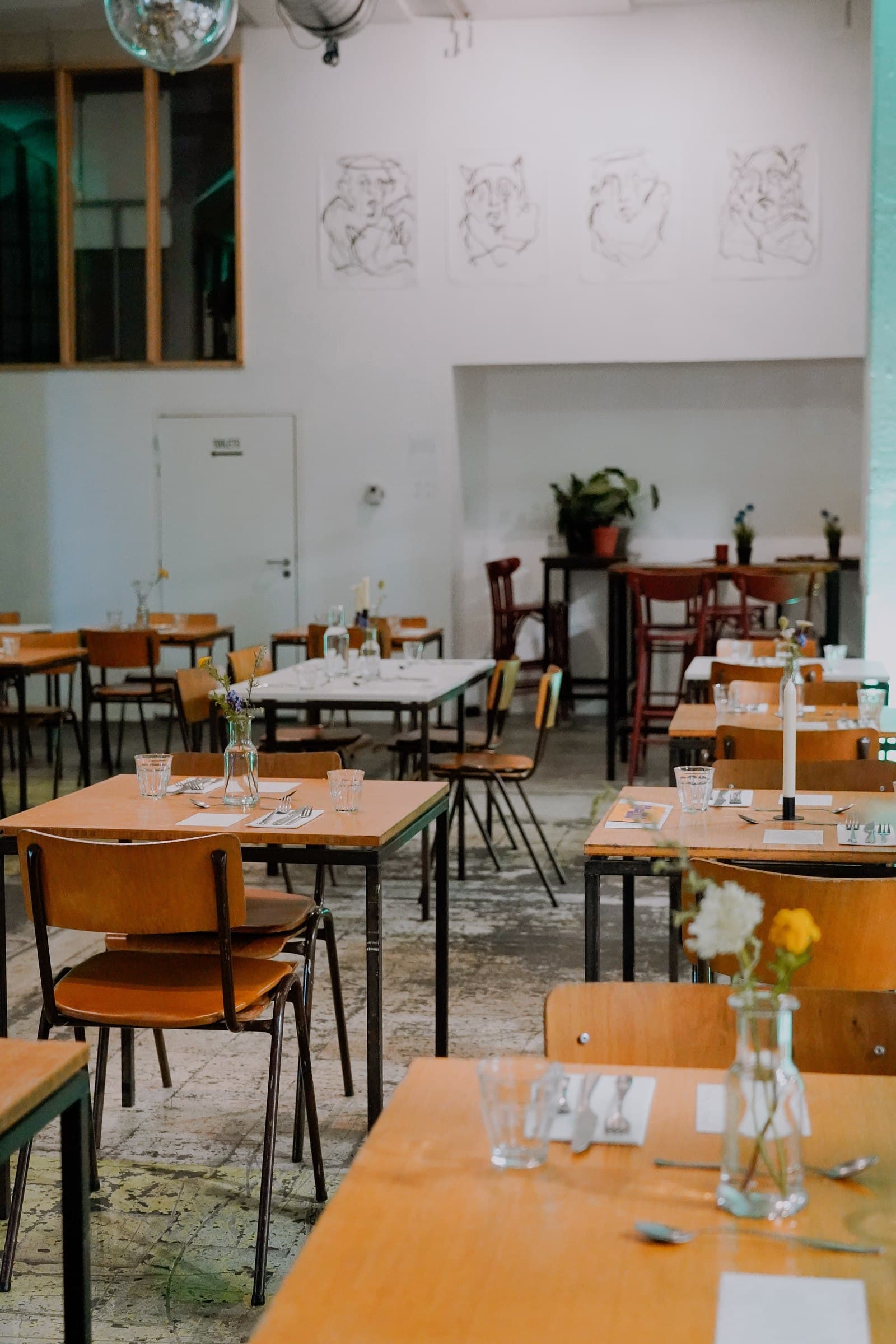 Empty wooden tables and chairs set out in the dining room.