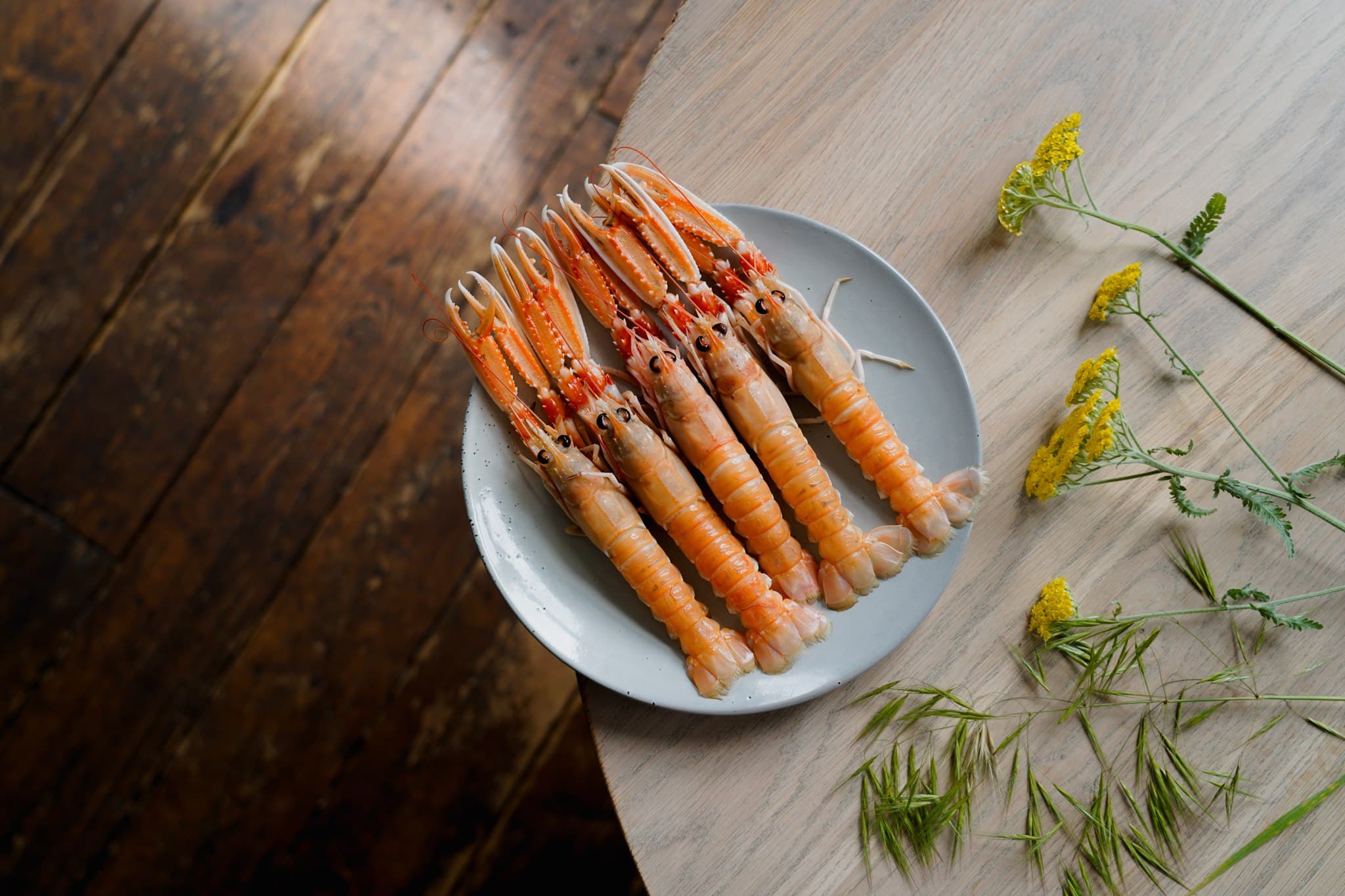 Carrots arranged on a white plate on a wooden table.