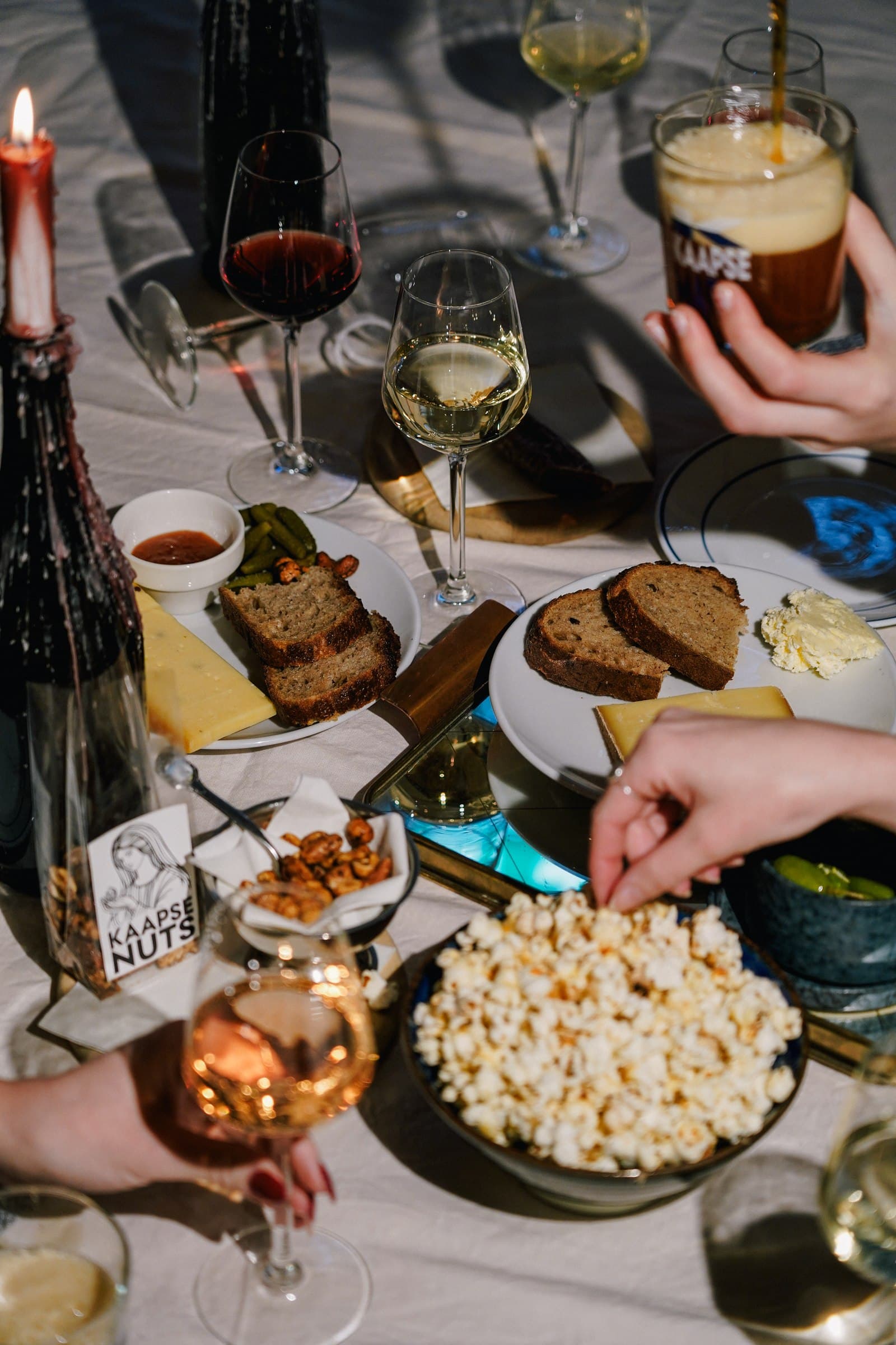 An overhead view of guests sharing food and drinks around a table.