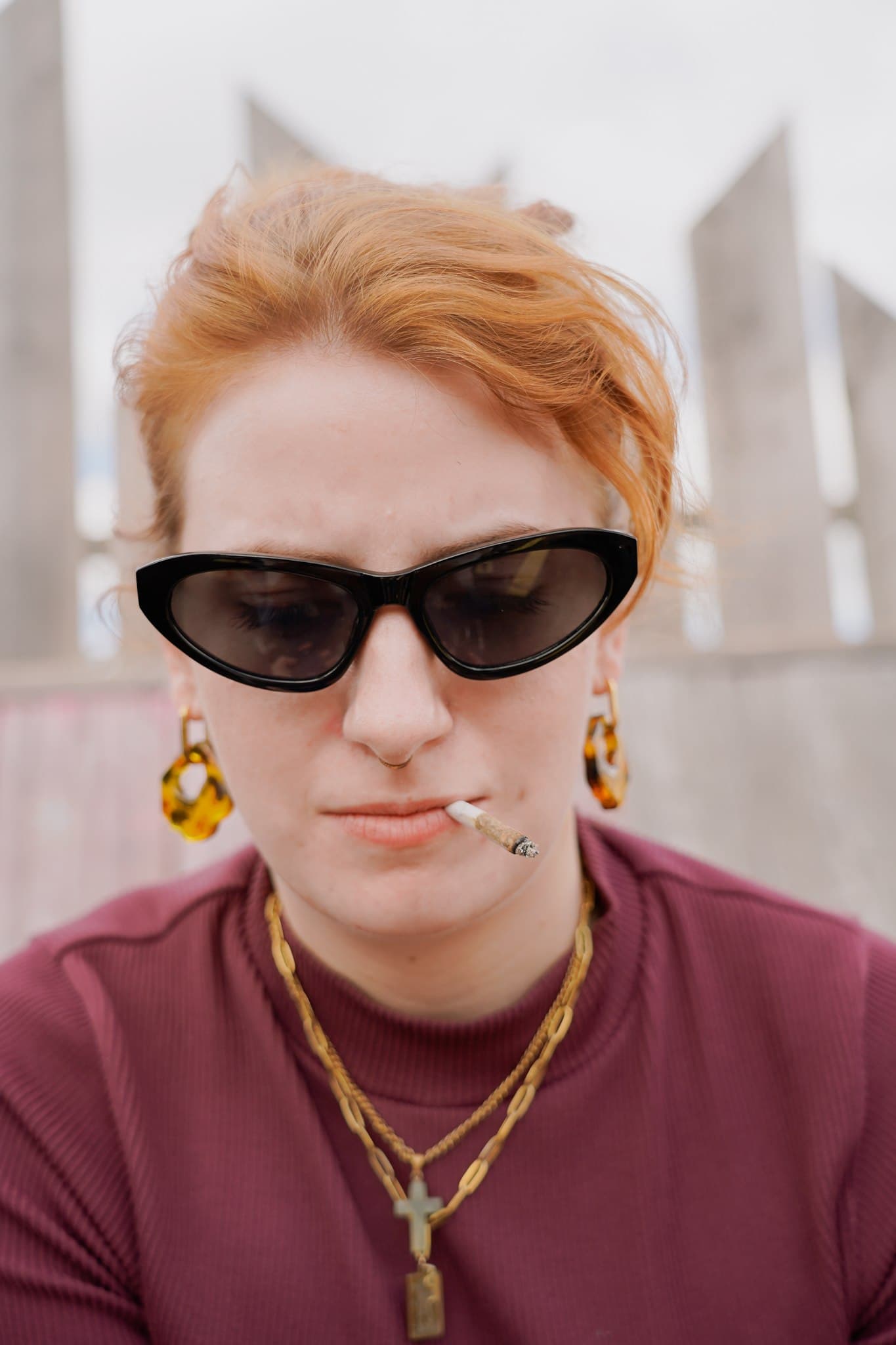 Close-up portrait of a person wearing sunglasses and a red top.