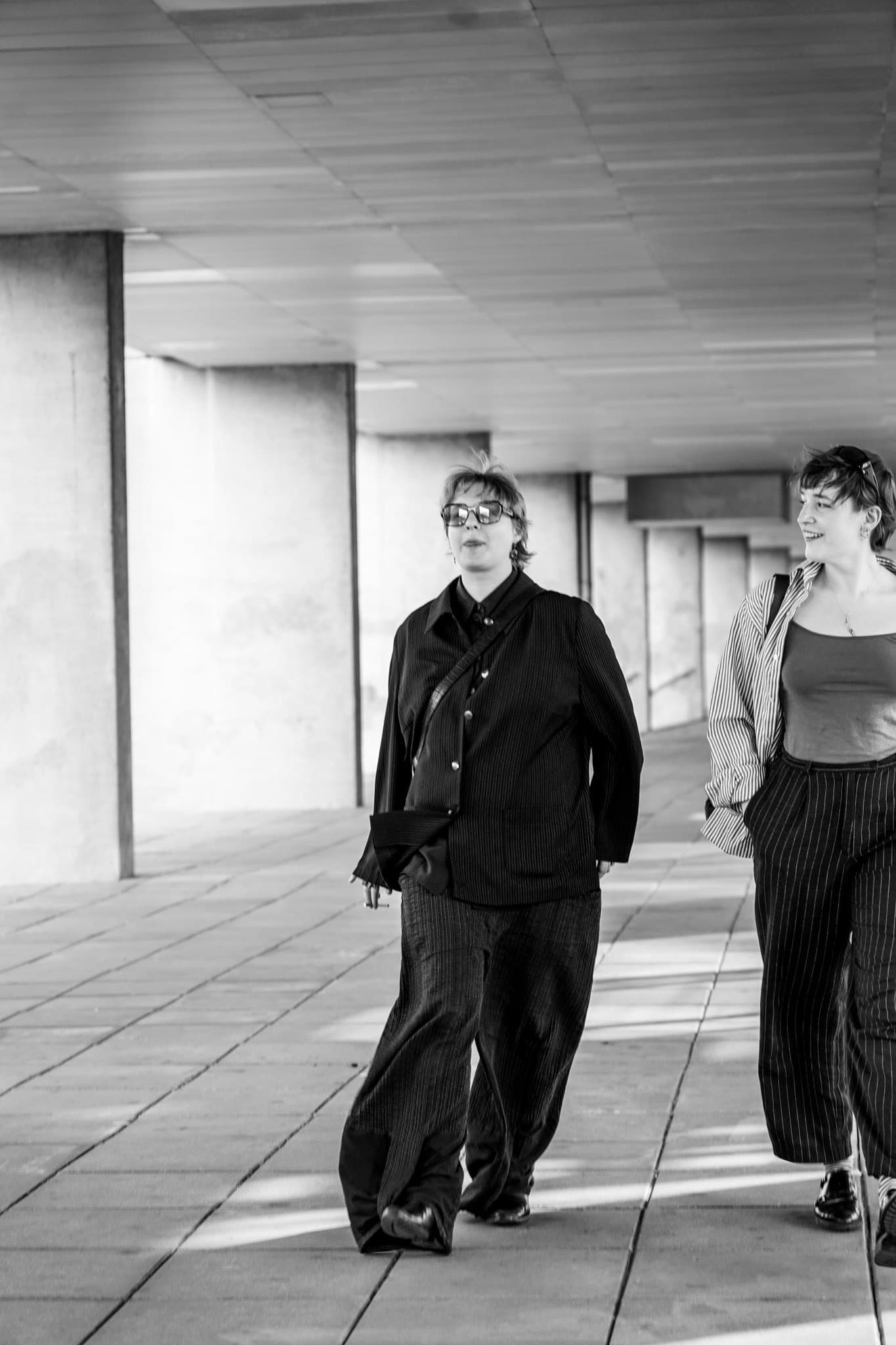 Black-and-white portrait in a concrete colonnade.