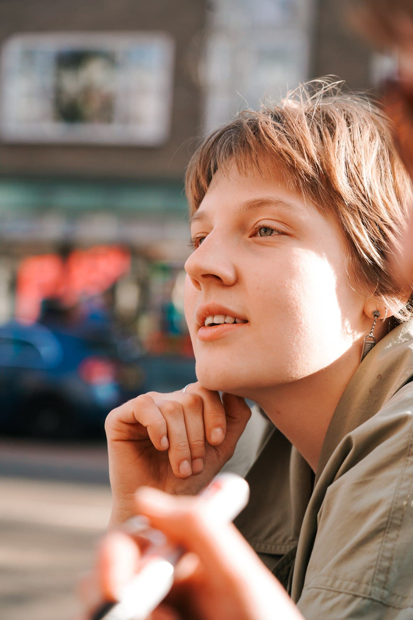 Close-up portrait of a person resting their chin on their hand.