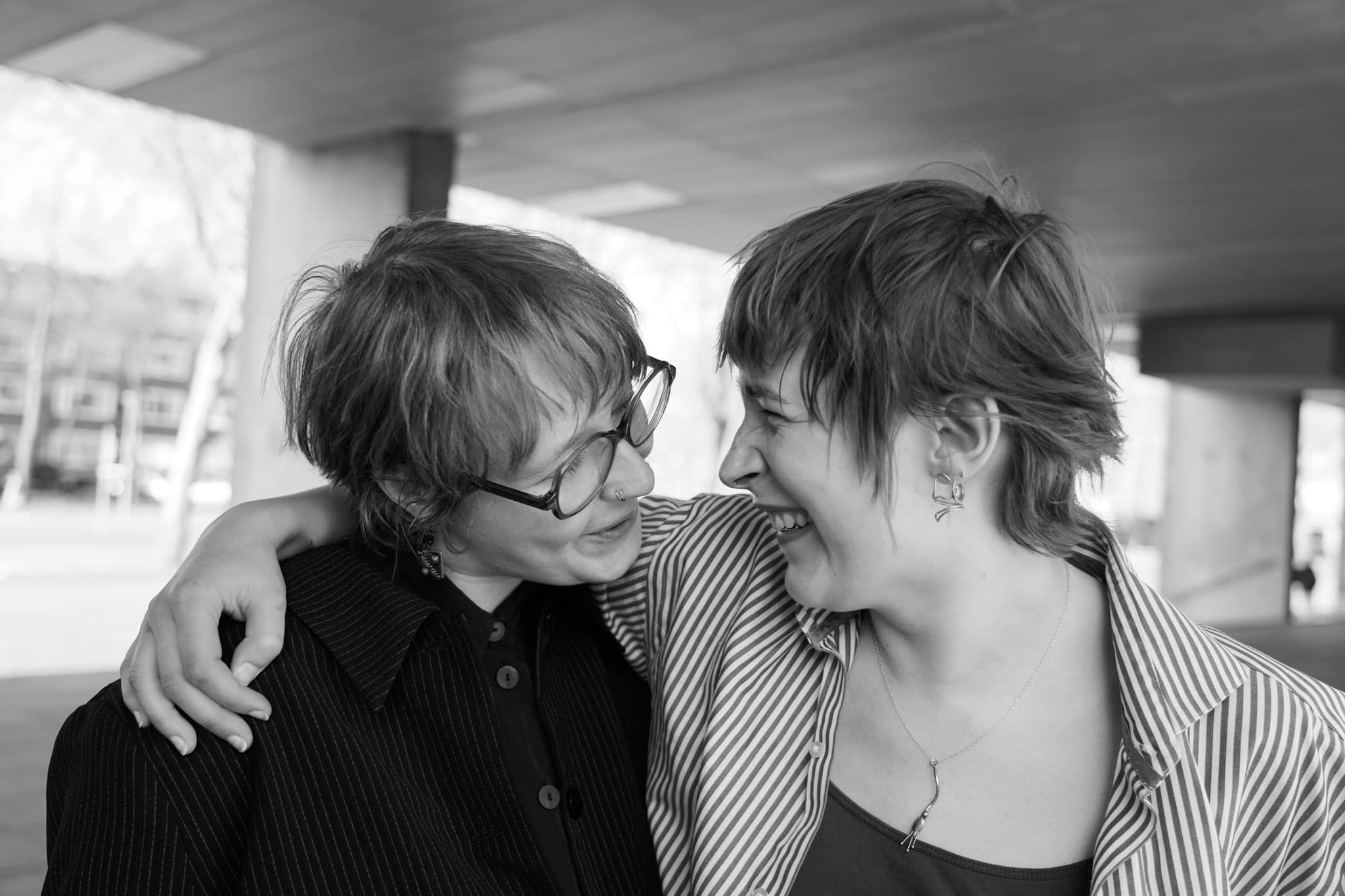 Black-and-white photograph of two people leaning towards each other.