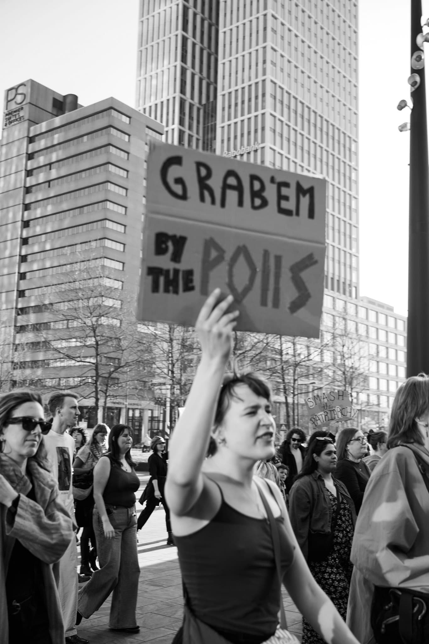 Black-and-white photograph of a crowd with protest signs.