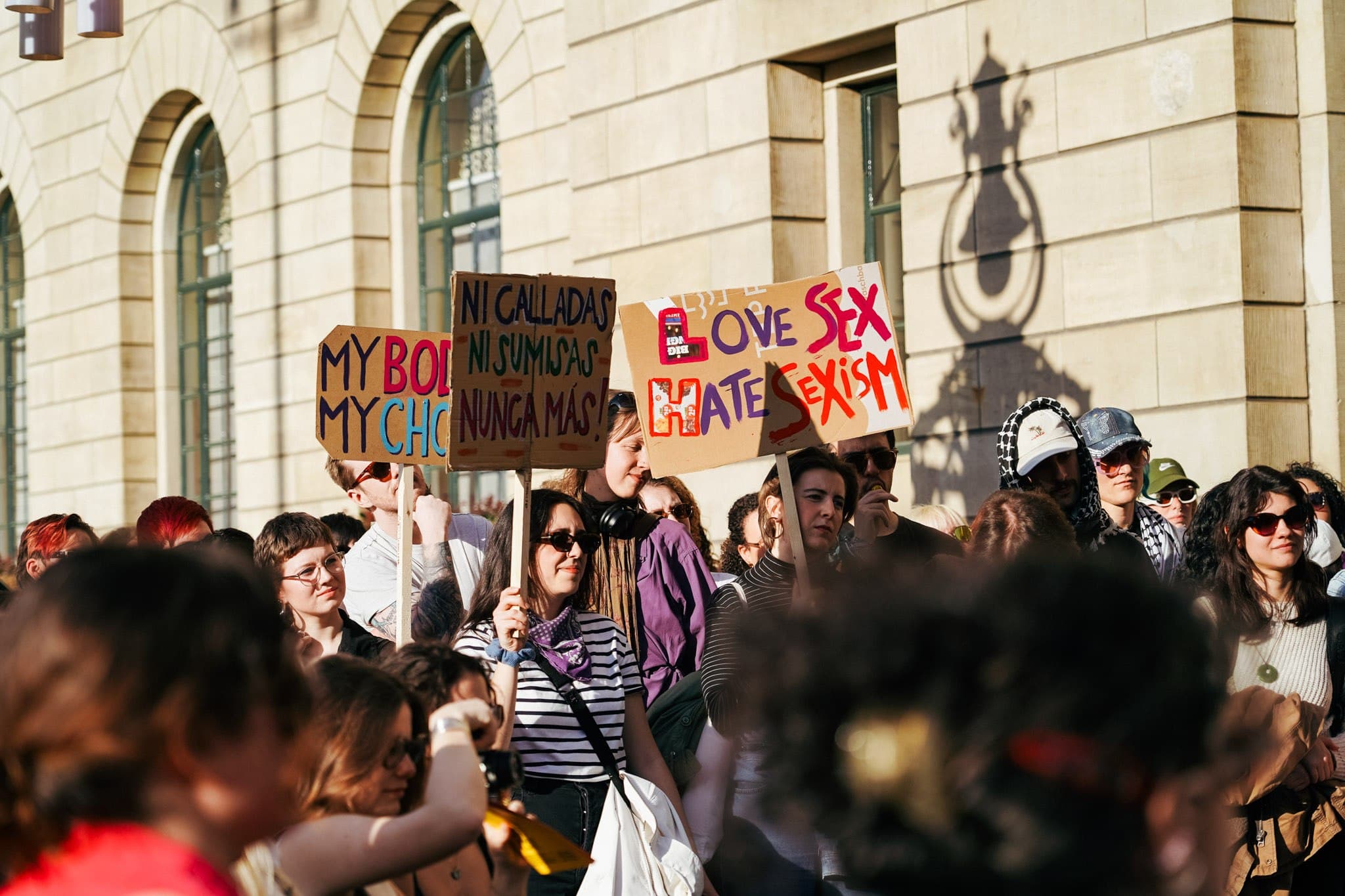 Demonstrators and handmade signs outside a city building.