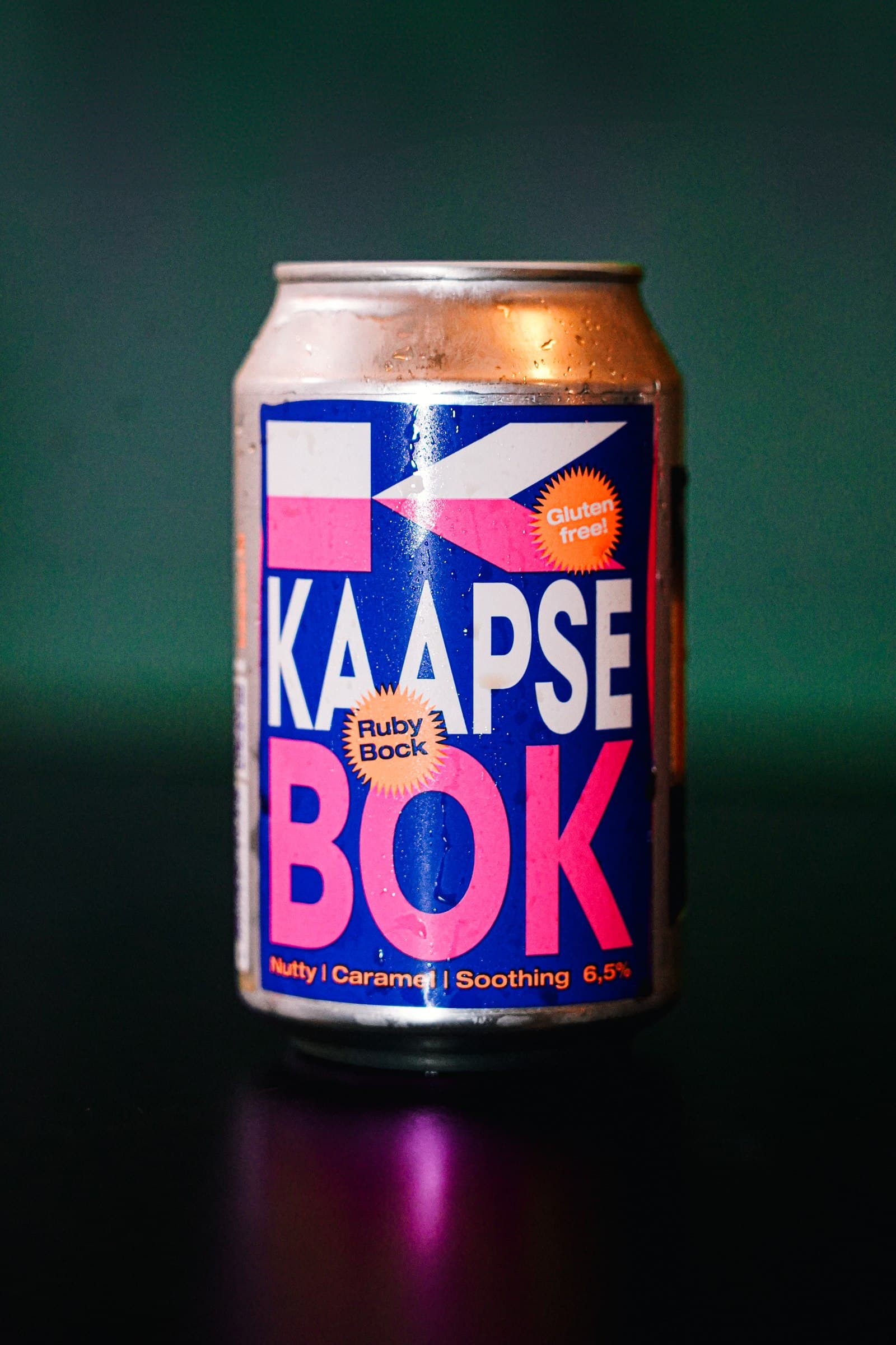 A Kaapse Bok beer can on a dark green background.