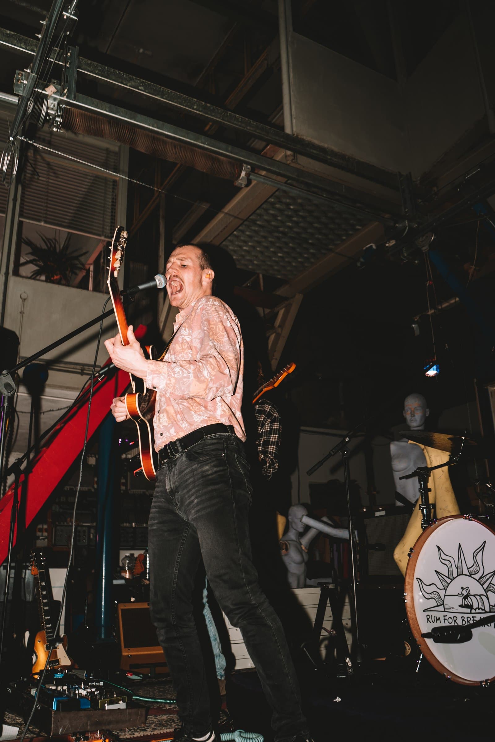 A musician performing on a dark indoor stage.
