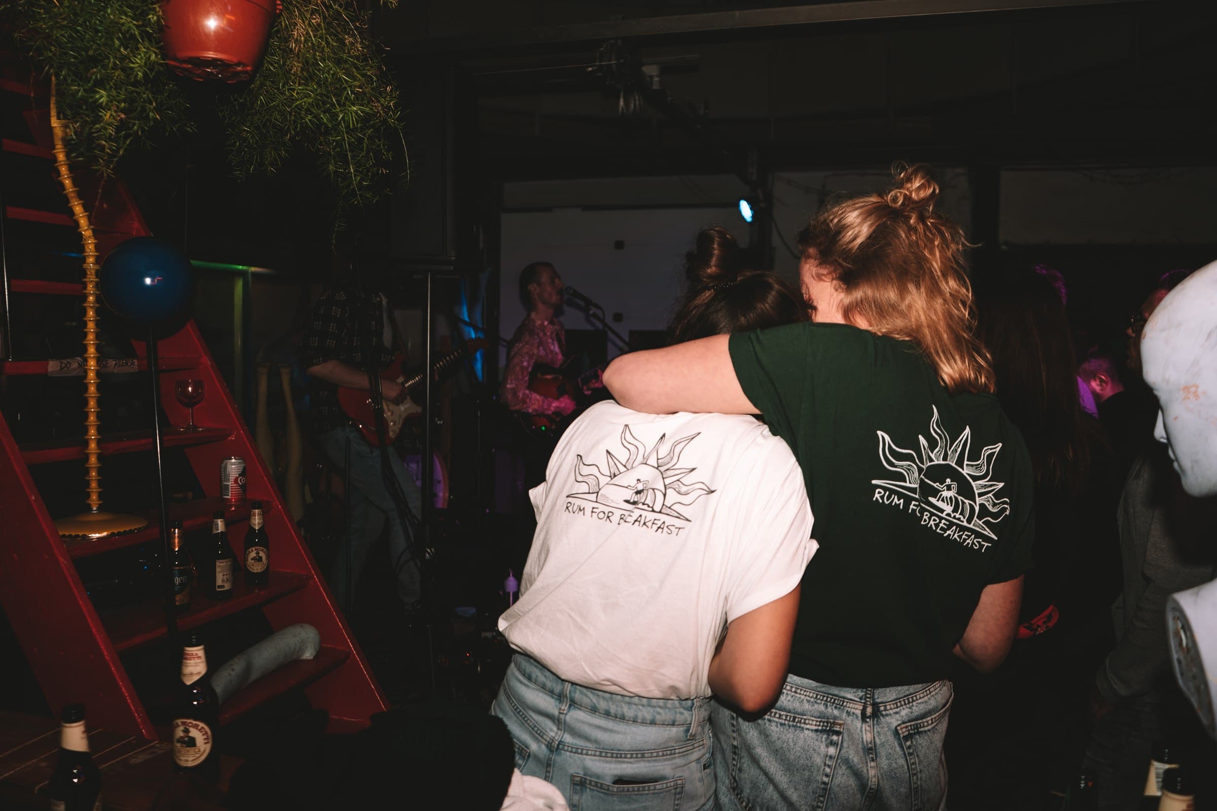 People standing in a dimly lit music venue.