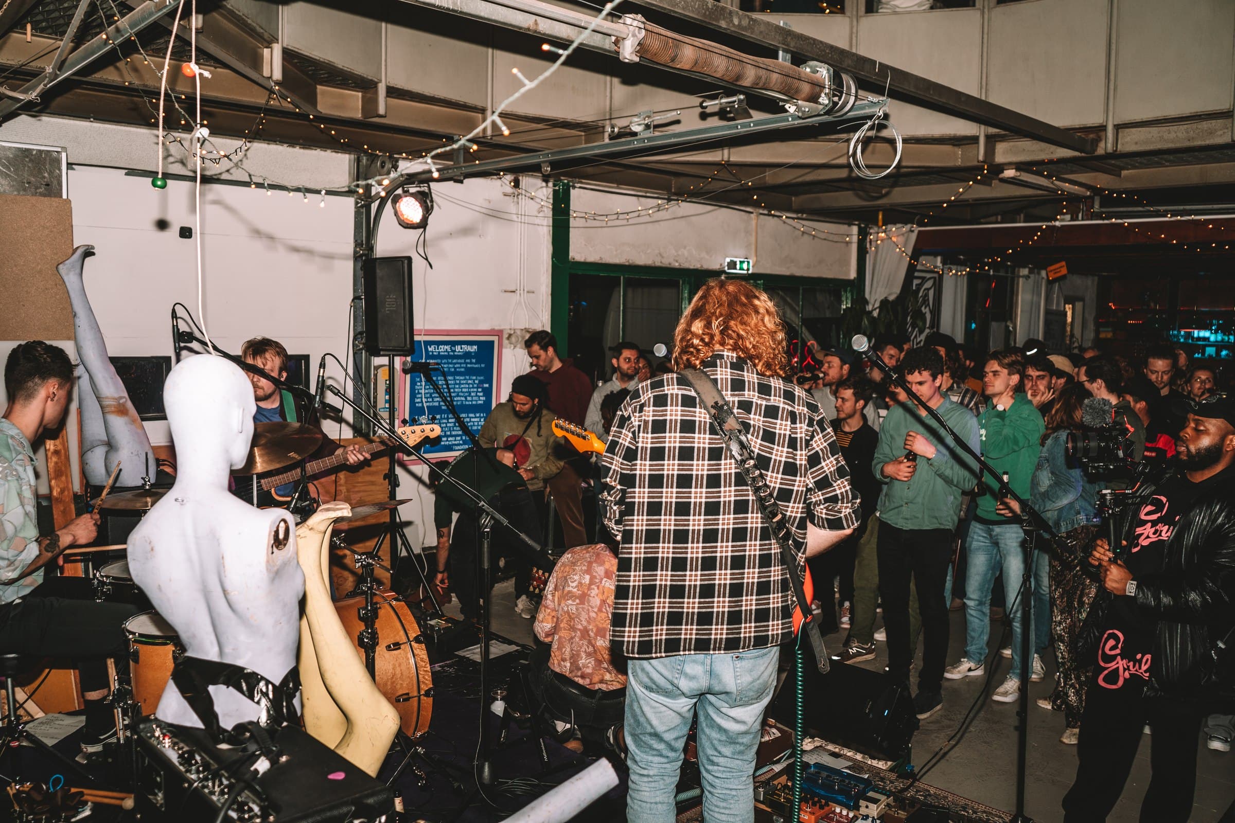 A crowd gathered around an outdoor performance area.