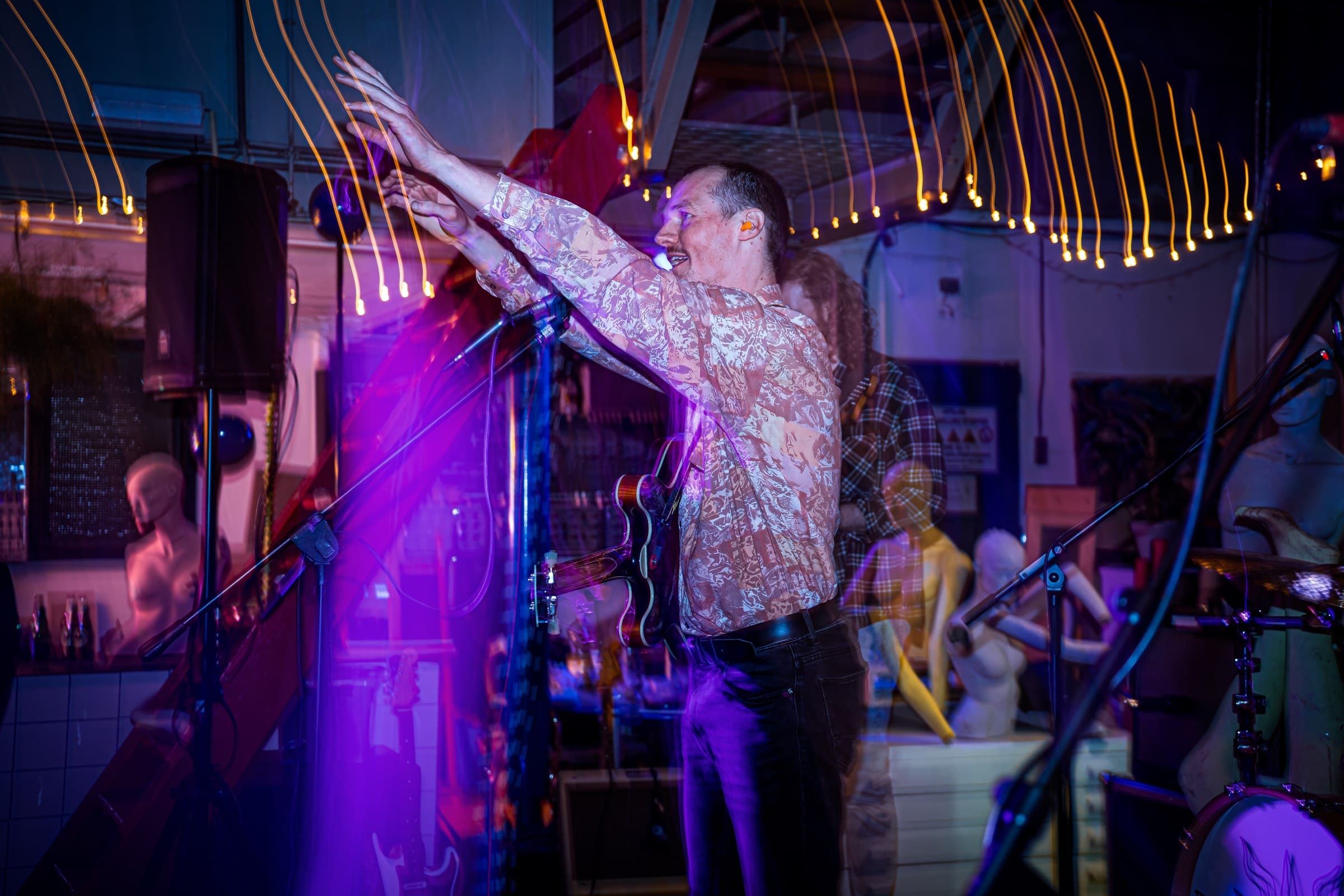 A live performance under purple and red stage lights.