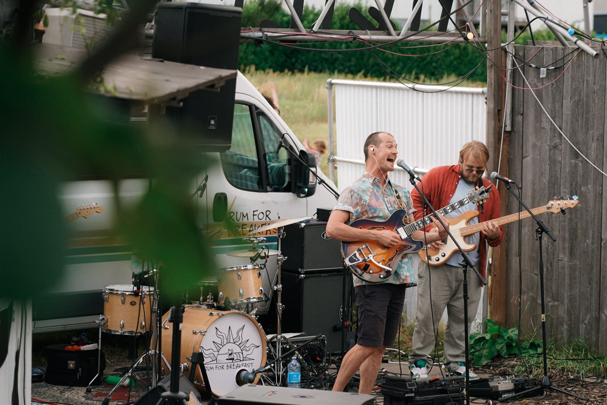 Rum for Breakfast performing outdoors beside a white van.