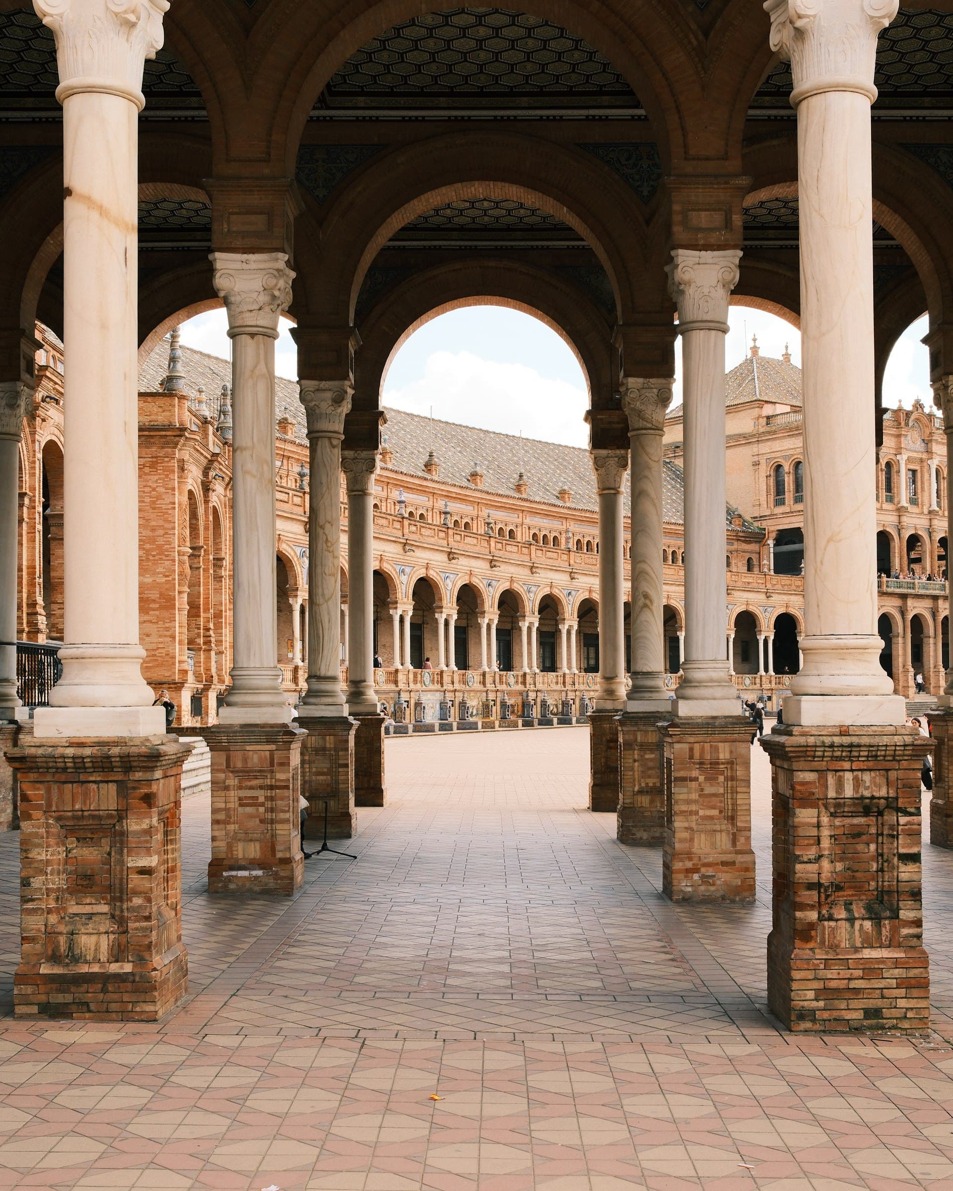 Stone columns and decorative arches overlooking a plaza.
