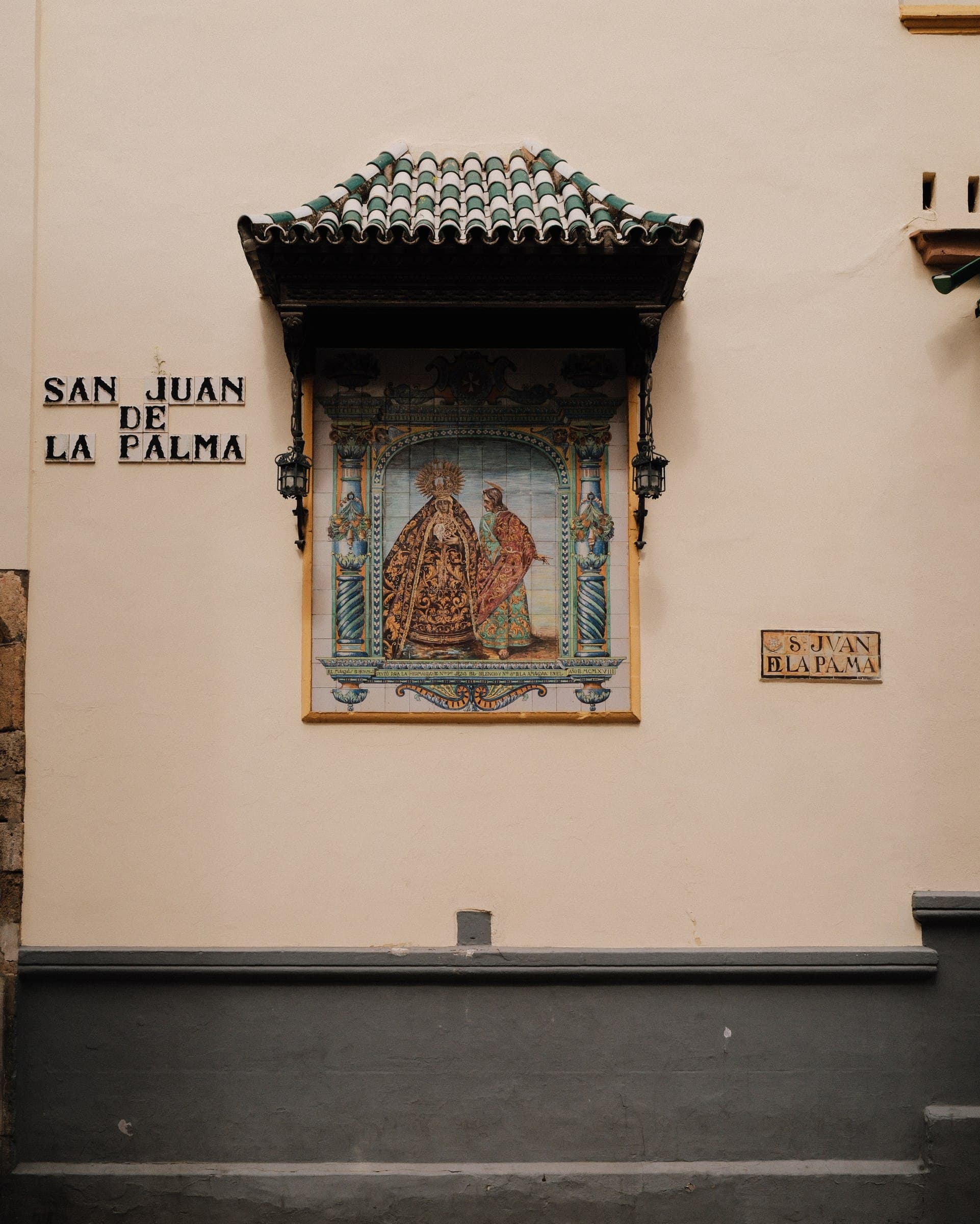 A decorative tile shrine set into a pale wall.