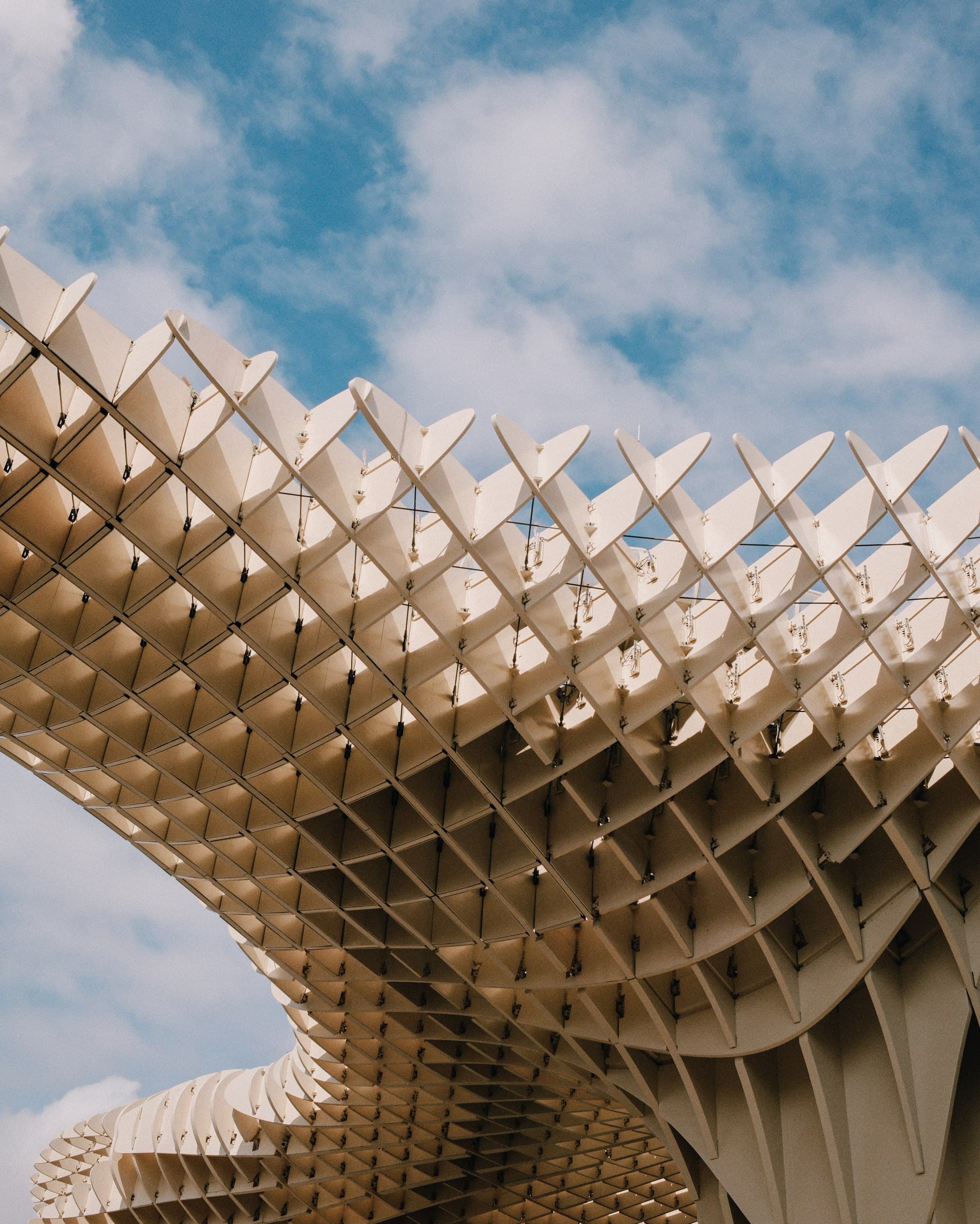 The geometric wooden canopy of the Setas de Sevilla against blue sky.