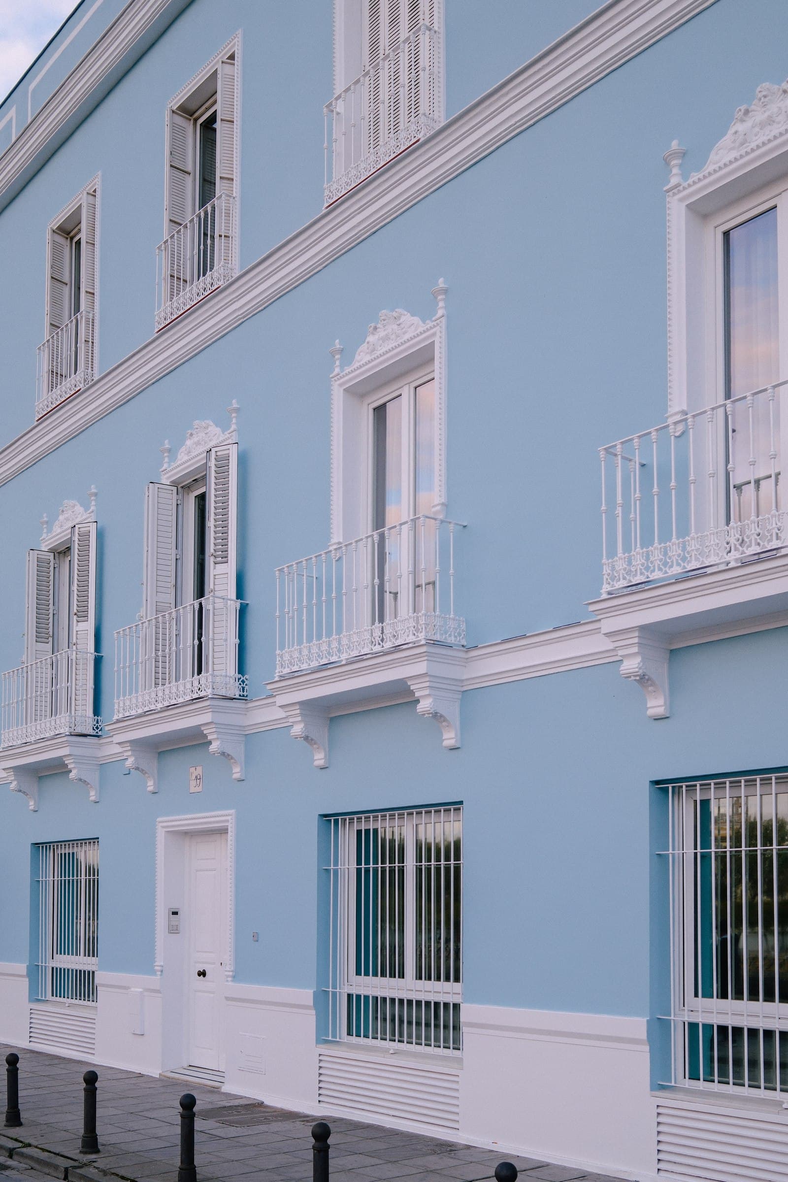 Pastel blue facade with white window surrounds.