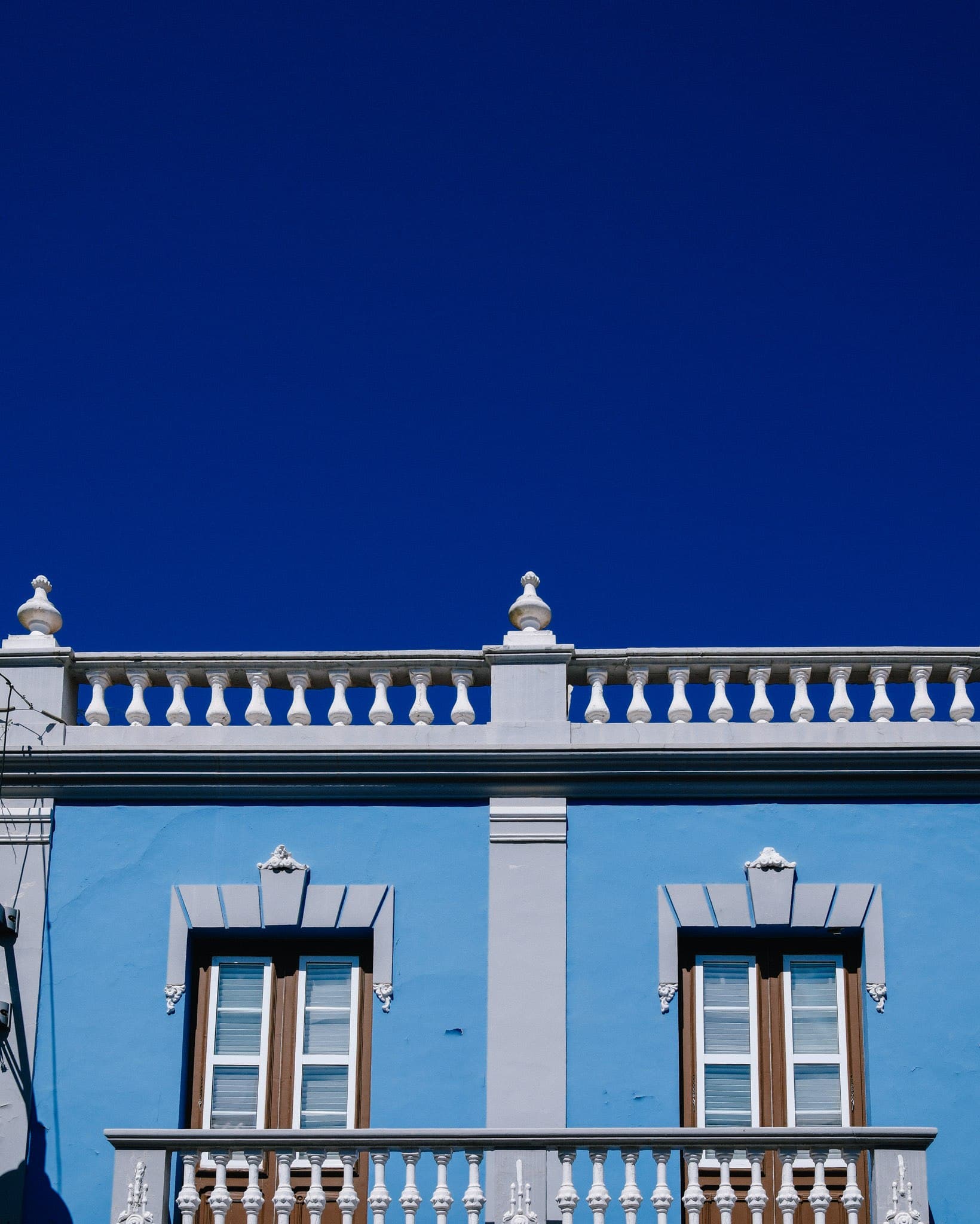 Blue building with white architectural details beneath a deep blue sky.
