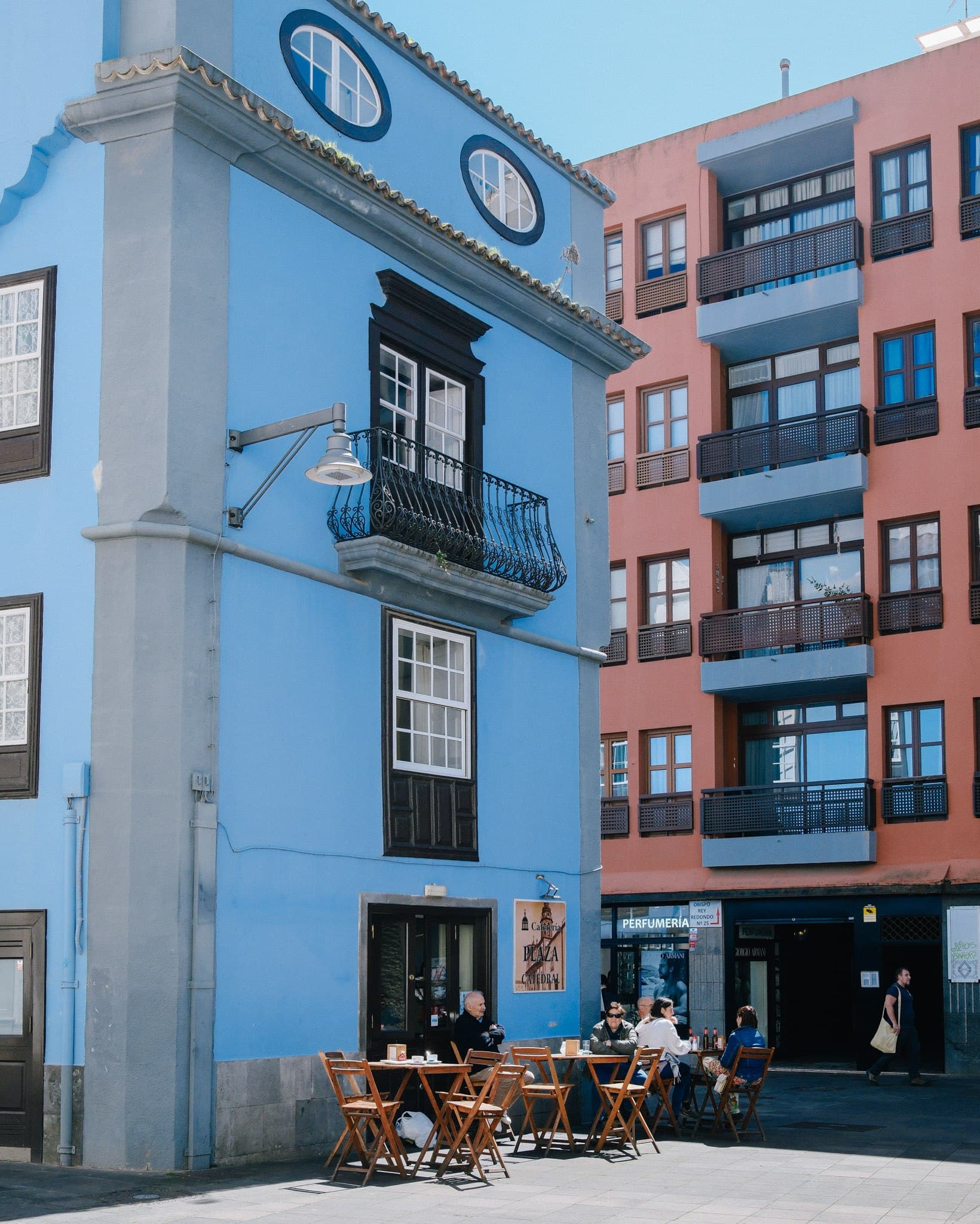 White corner building beside colourful urban facades.