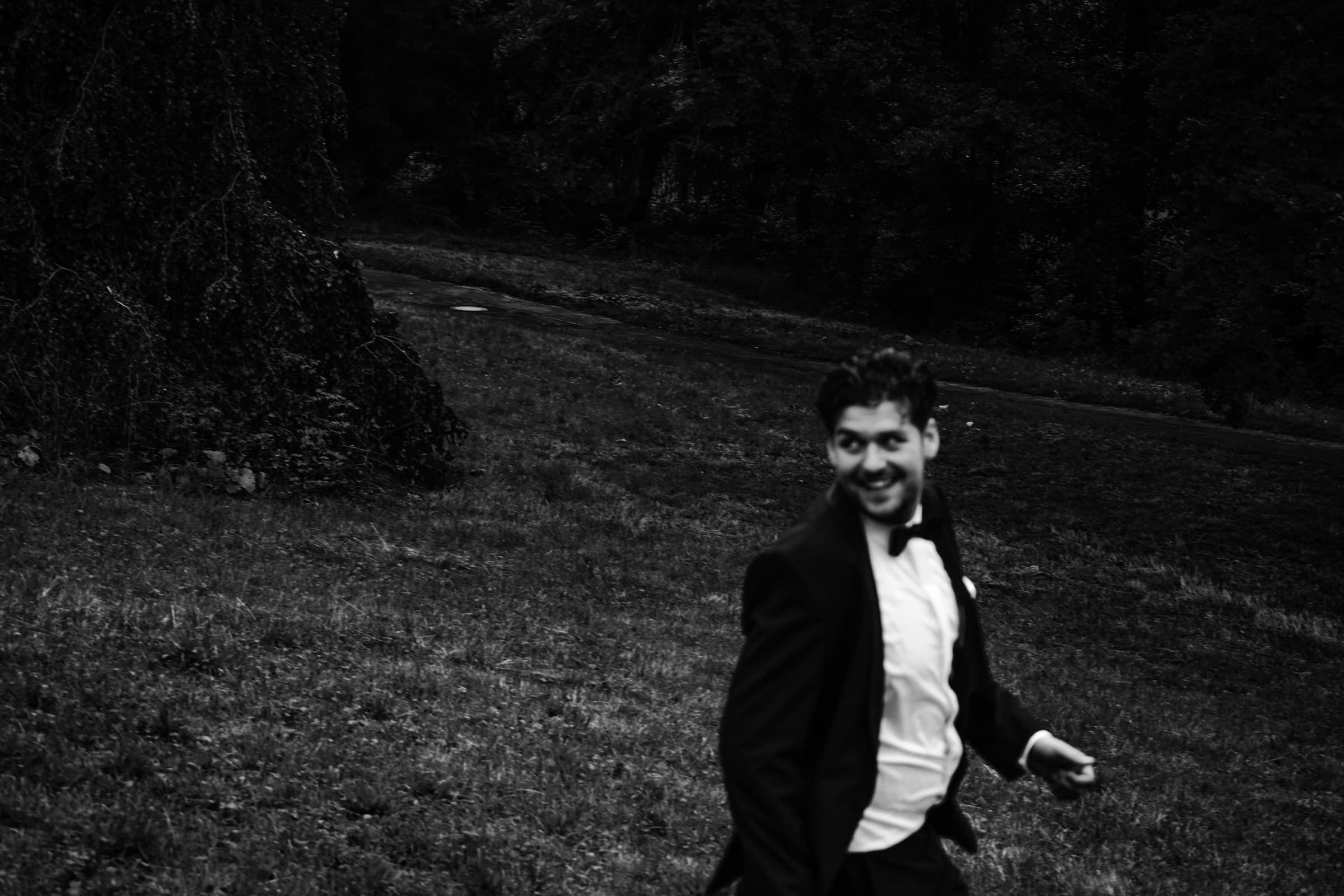 Black-and-white portrait of the groom outdoors.