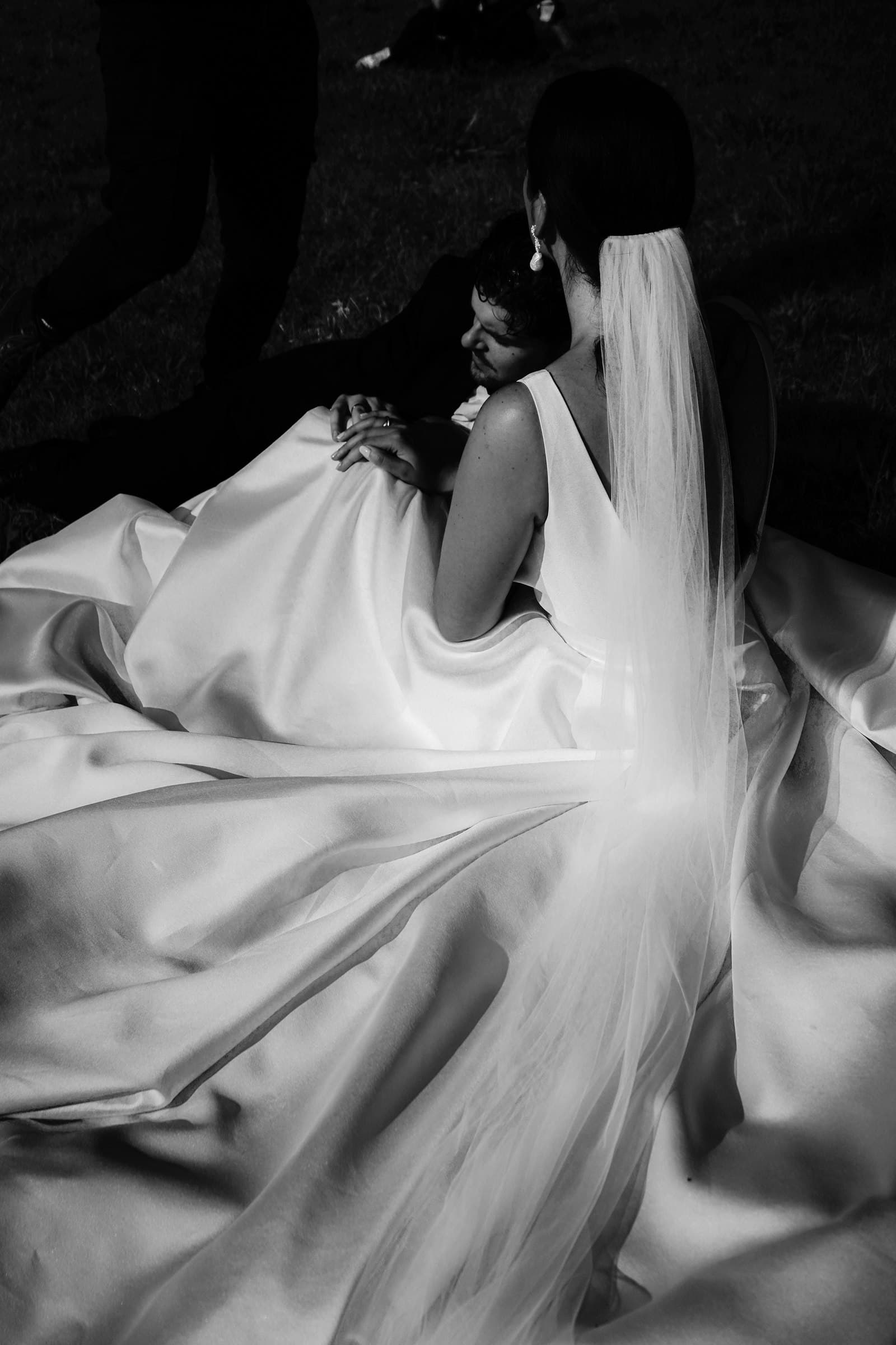 Close-up of the wedding dress fabric and a hand in black and white.