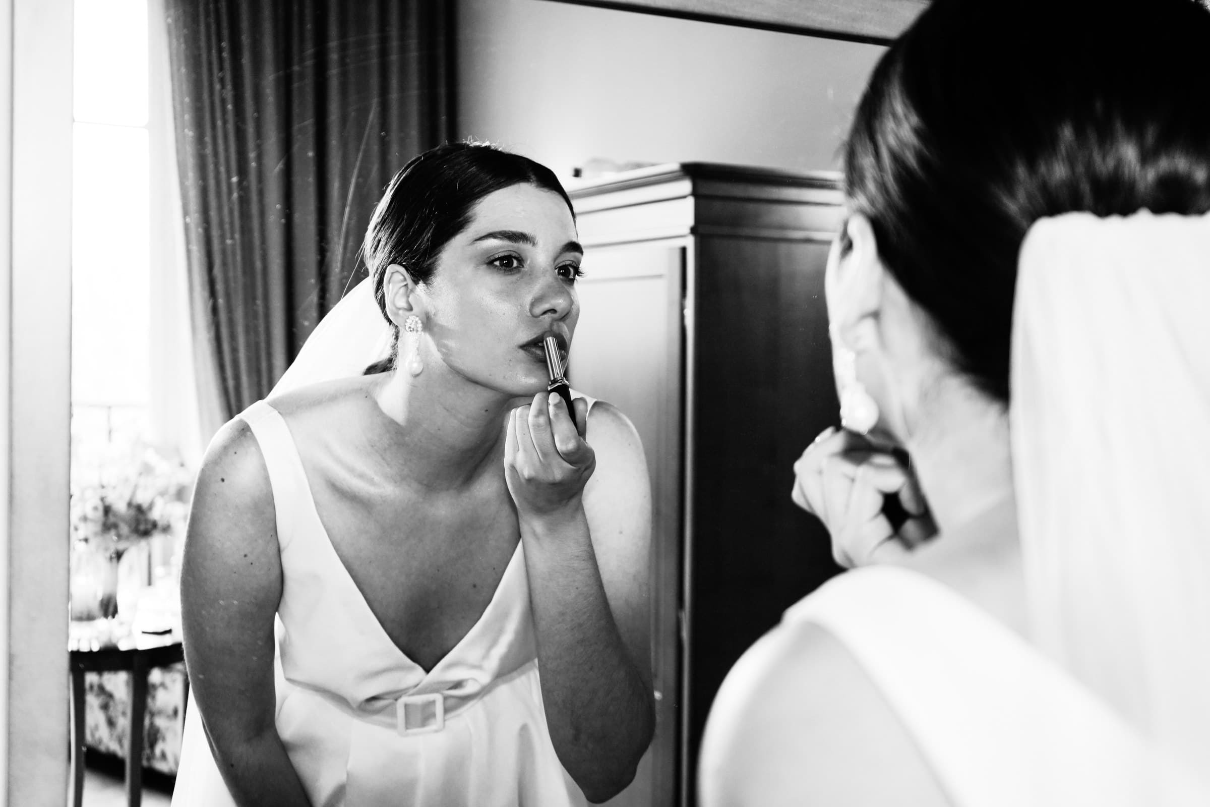 The bride having her make-up applied in black and white.