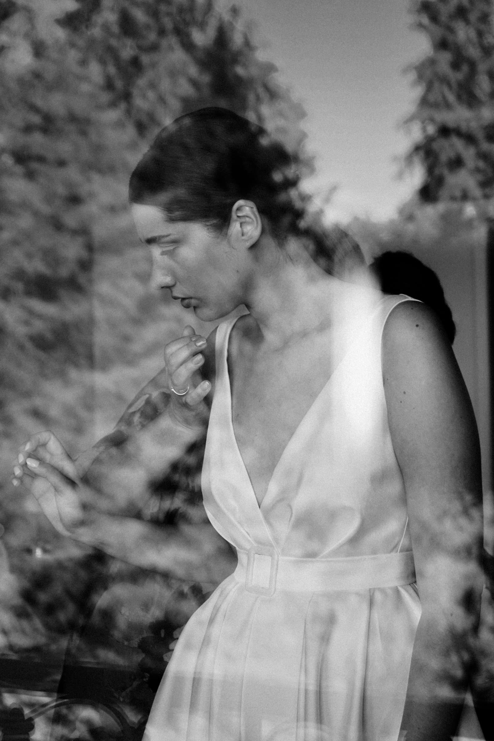 Black-and-white outdoor portrait of the bride looking down.
